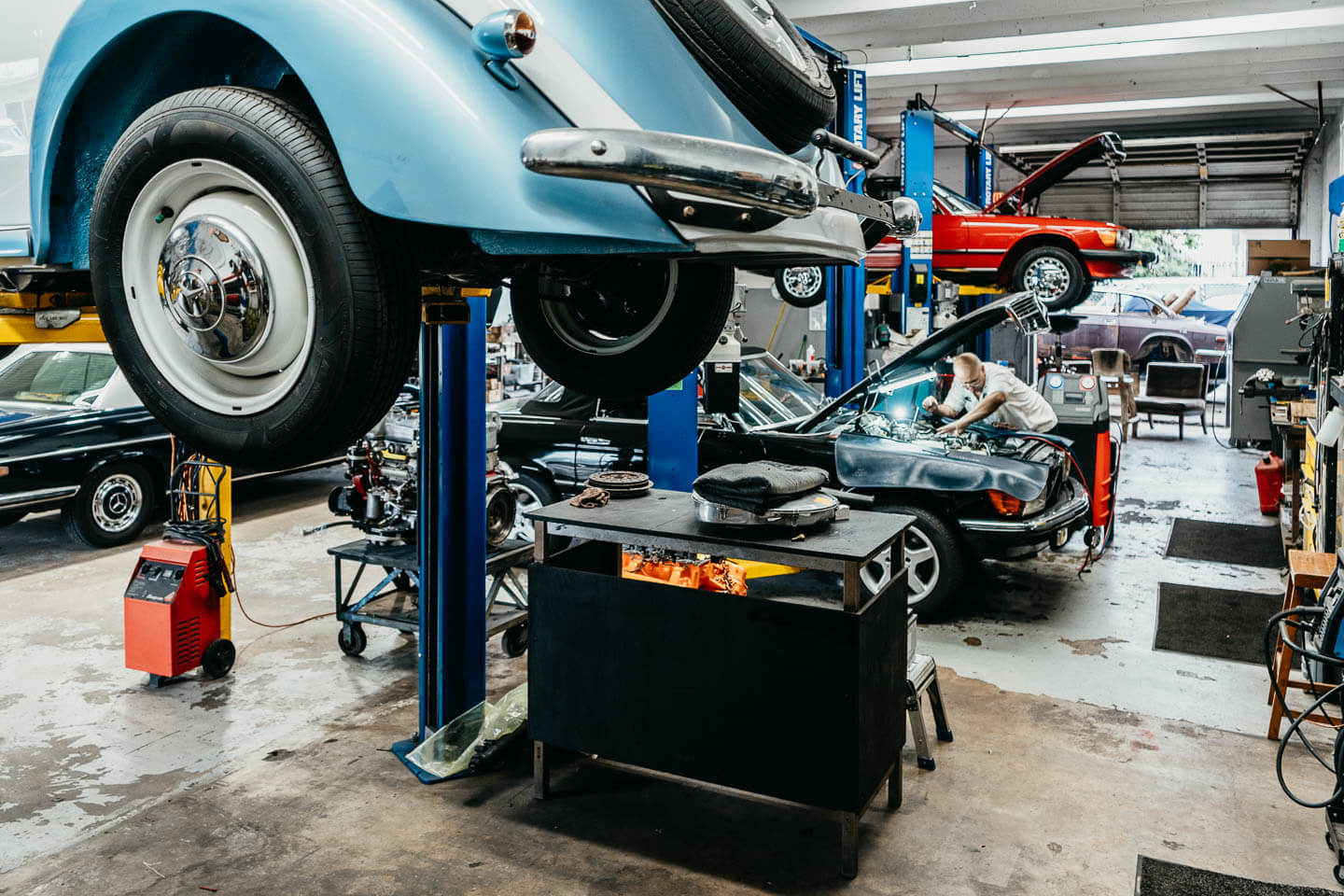 Skilled mechanic conducting a tire check and wheel alignment on a classic car at Miami Benz’s state-of-the-art facility.