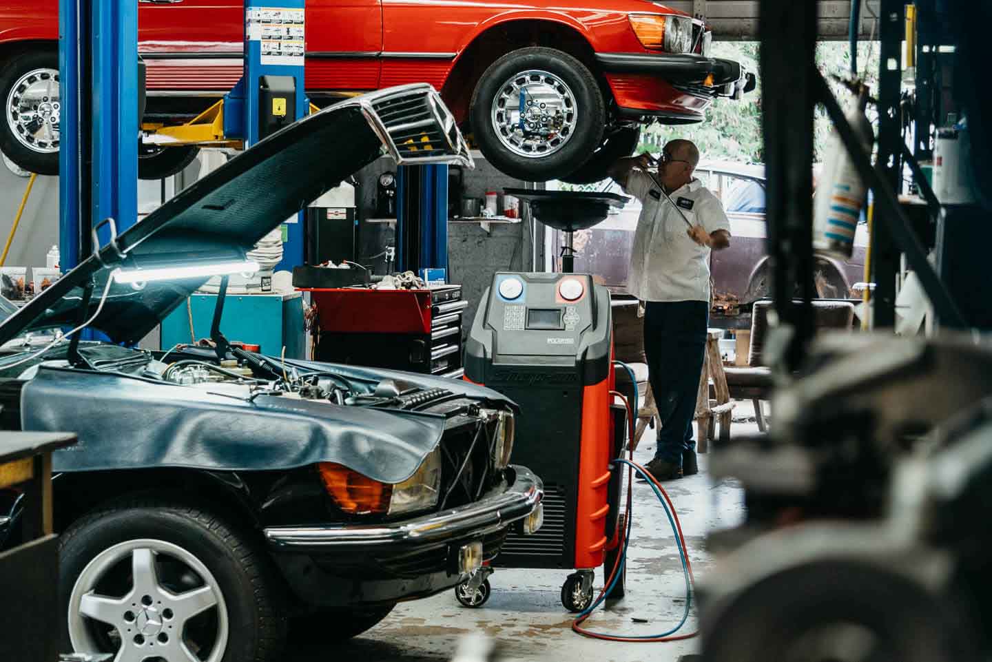 Mercedes-Benz undergoing AC diagnostics at Miami Benz workshop in South Miami, with technician and specialized equipment.