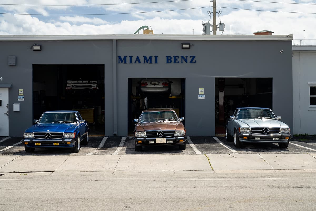 Miami Benz workshop on Commerce Lane in South Miami with three classic Mercedes-Benz cars parked outside.