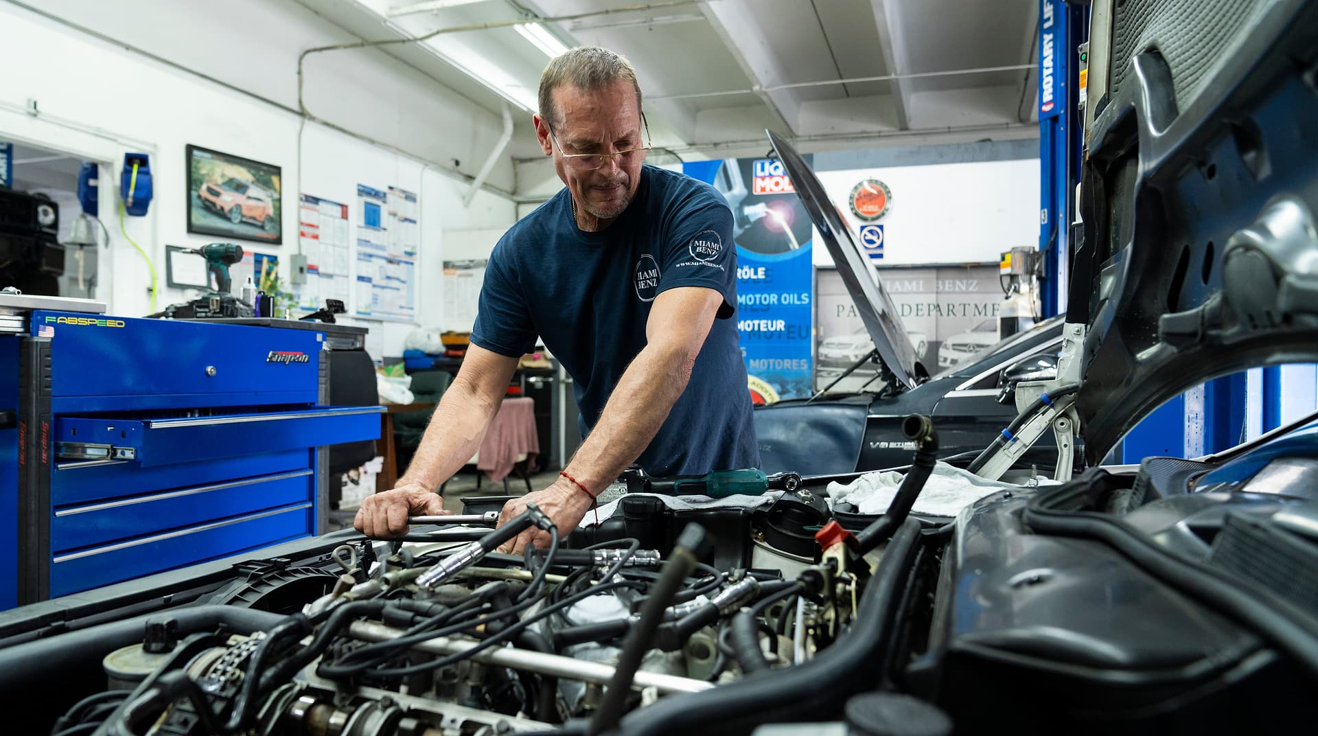 Miami Benz technician working on a Mercedes-Benz engine in the South Miami workshop.