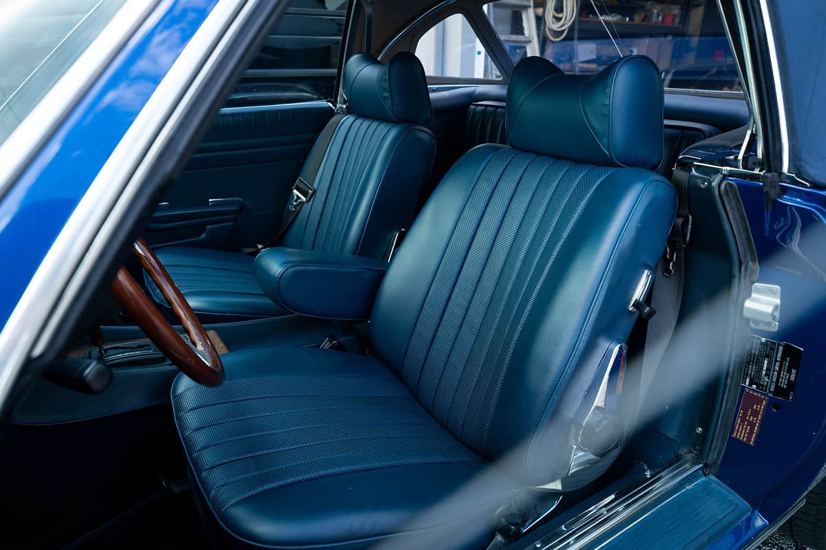 Blue leather seats and wood-trimmed cabin of the restored 1979 Mercedes-Benz 450 SL.
