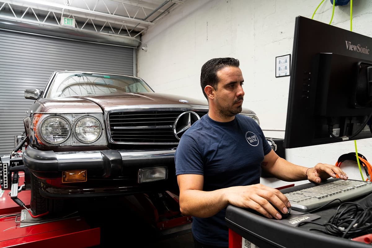Miami Benz technician at the wheel alignment computer, with a Mercedes-Benz SL on the alignment rig.